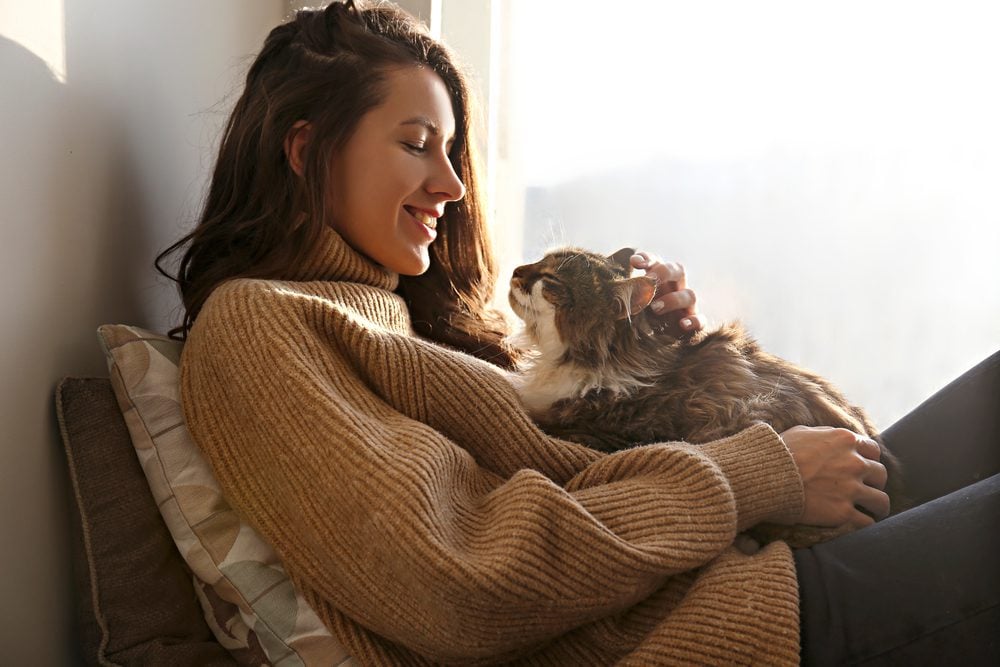 Young woman with a cat on her lap
