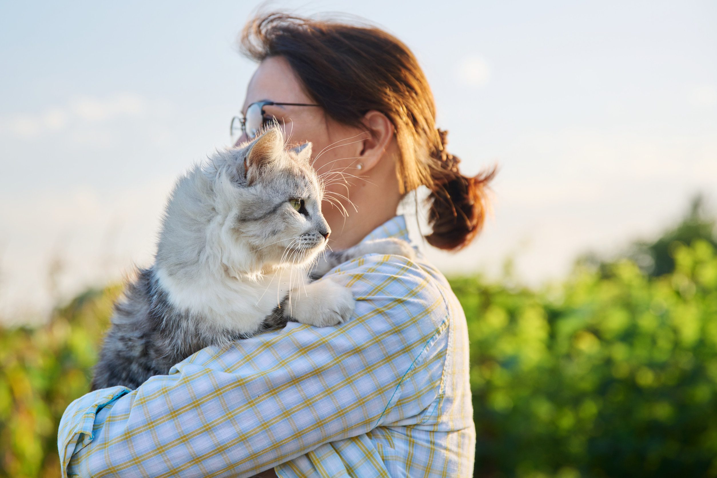 A woman in a checkered shirt holding her emotional support animal in Vancouver, WA.